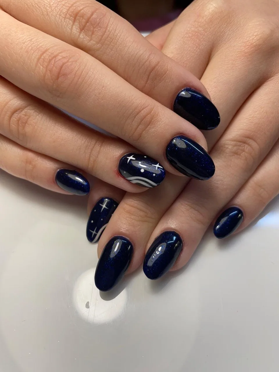 Uñas azul noche con brillo y estrellas pintadas a mano