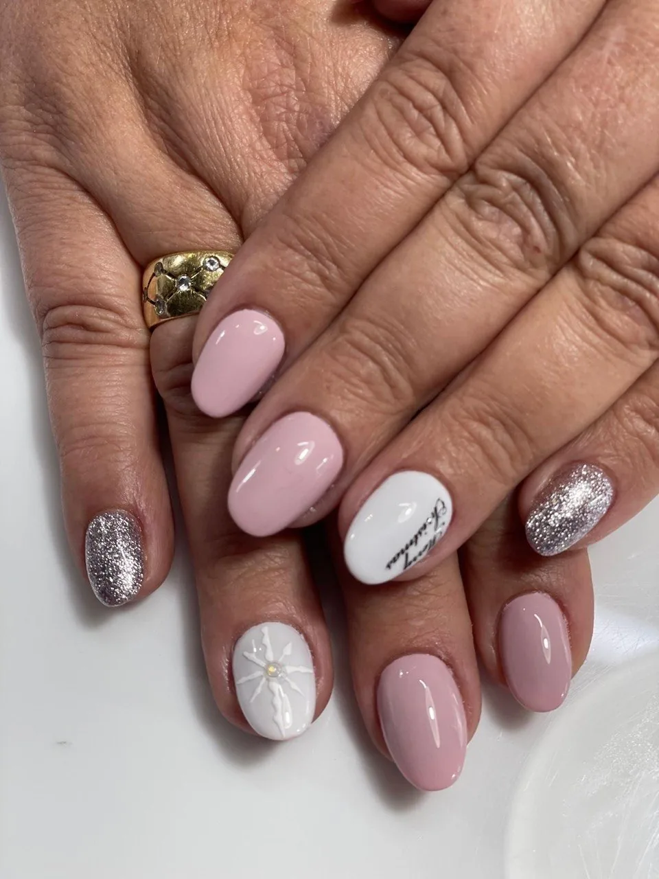Manicura rosa y blanca con glitter plata y diseño navideño
